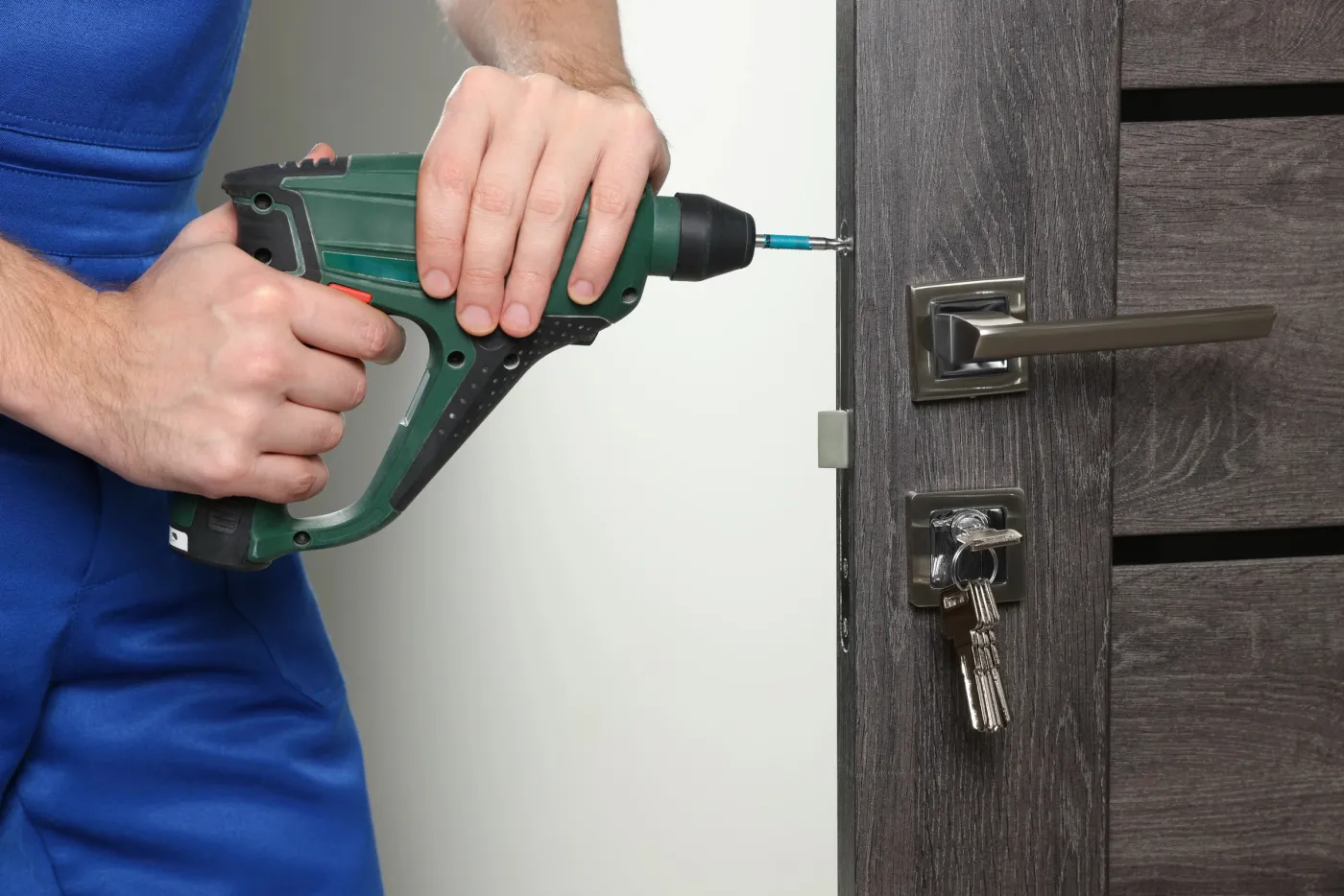Artisan ajustant une serrure de sûreté sur une porte ancienne dans le 6e arrondissement